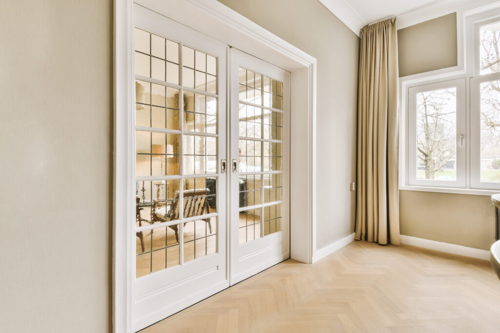 a living room with entry doors leading to a dining room